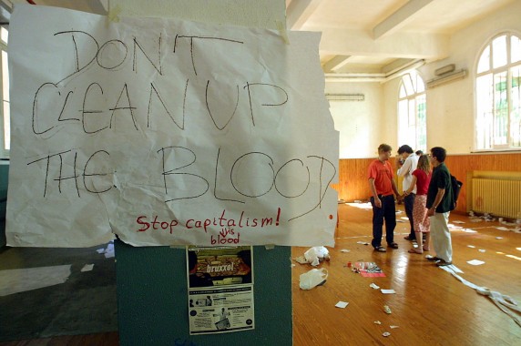 A note reading "Don't Clean Up The Blood" hangs in the headquarters of the umbrella anti-globalisation protest movement, the Genoa Social Forum (GSF), 22 July 2001 after an overnight police raid in Genoa. Activists at the scene appeared shaken and horrified by the police action, calling it an unprovoked and brutal attack, as a helicopter hovering at rooftop height lit up the streets with floodlights. AFP PHOTO GERARD JULIEN
