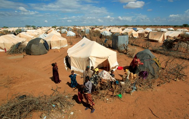 Refugees stand outside their tent at the Ifo Extension refugee camp in Dadaab, near the Kenya-Somalia border in Garissa County, Kenya